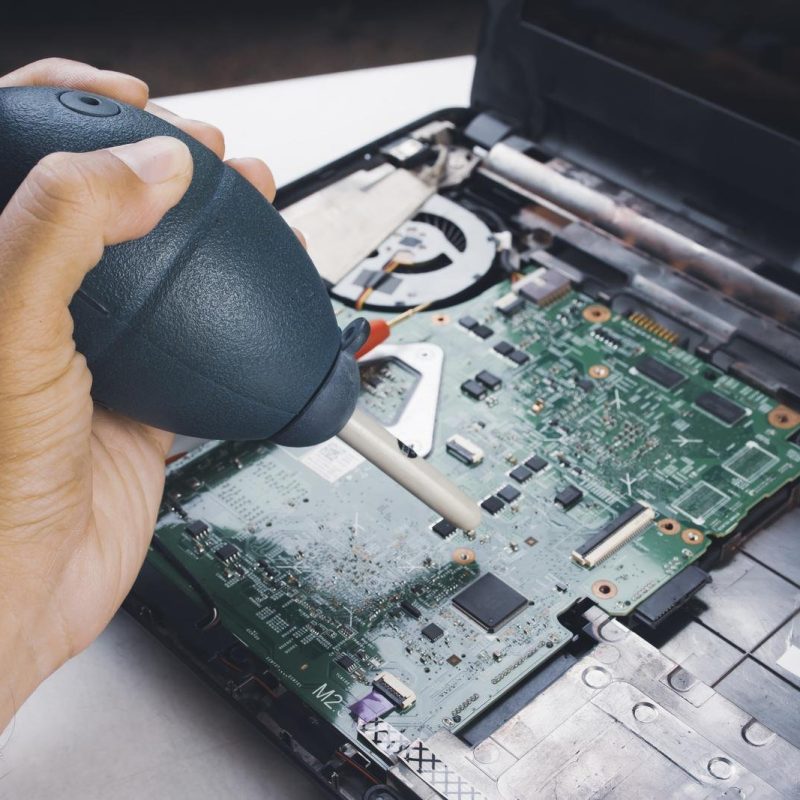 Technician blowing air to the motherboard for dust cleaning with